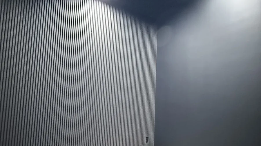 Finished wood slat accent wall against black walls in a Brooklyn lounge