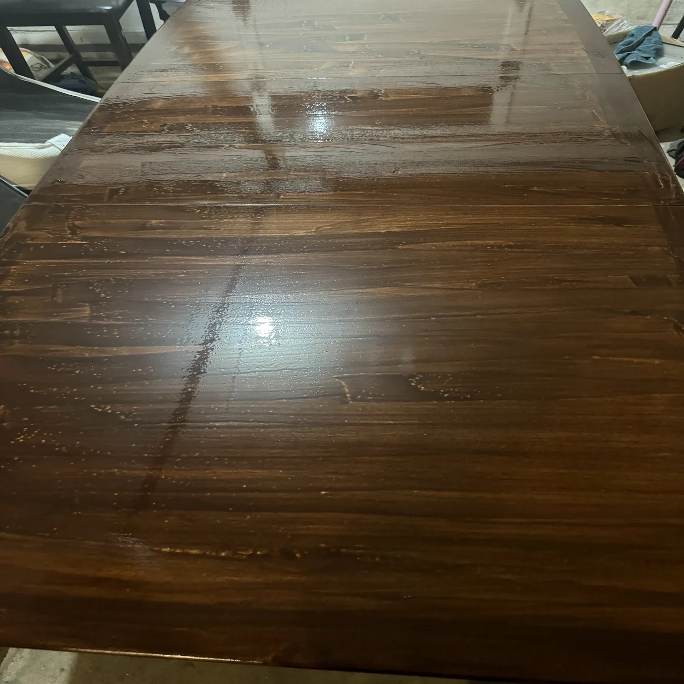 Stain freshly applied to the wood table to confirm the warmer wood tone before the protective polyurethane finish