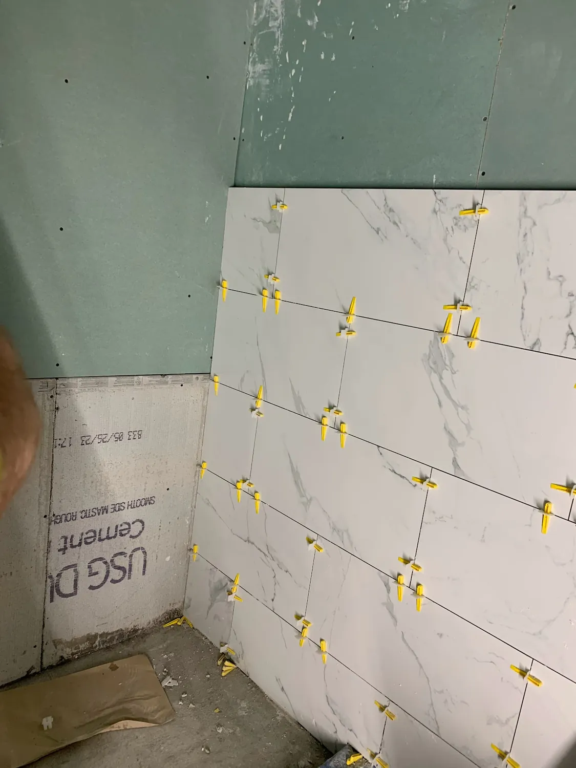 Waterproof cement board on bathroom walls as large-format marble-look tile installation begins