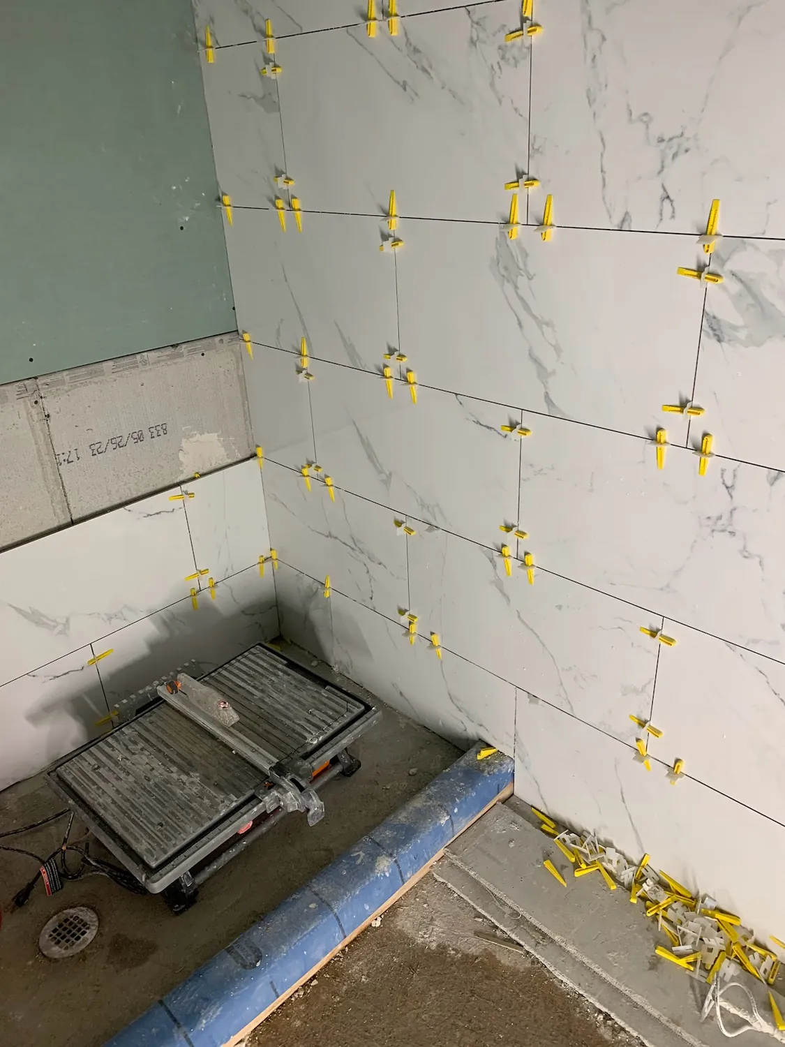 Cutting and fitting marble-look shower wall tile with a wet saw on site