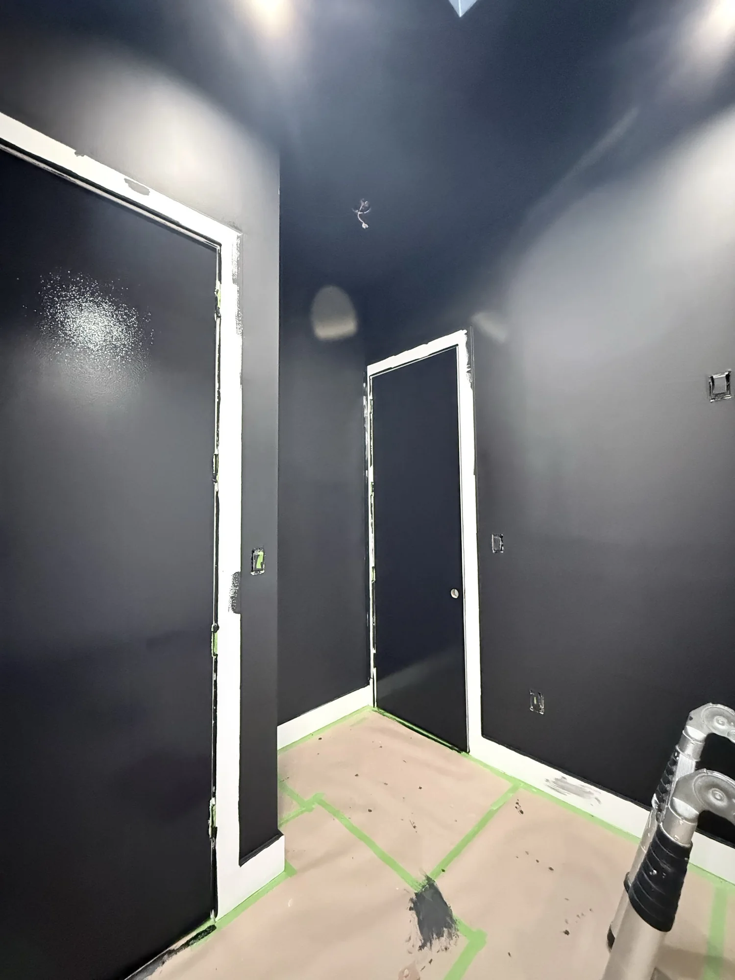 Room walls and door being painted black with crisp cut-in lines