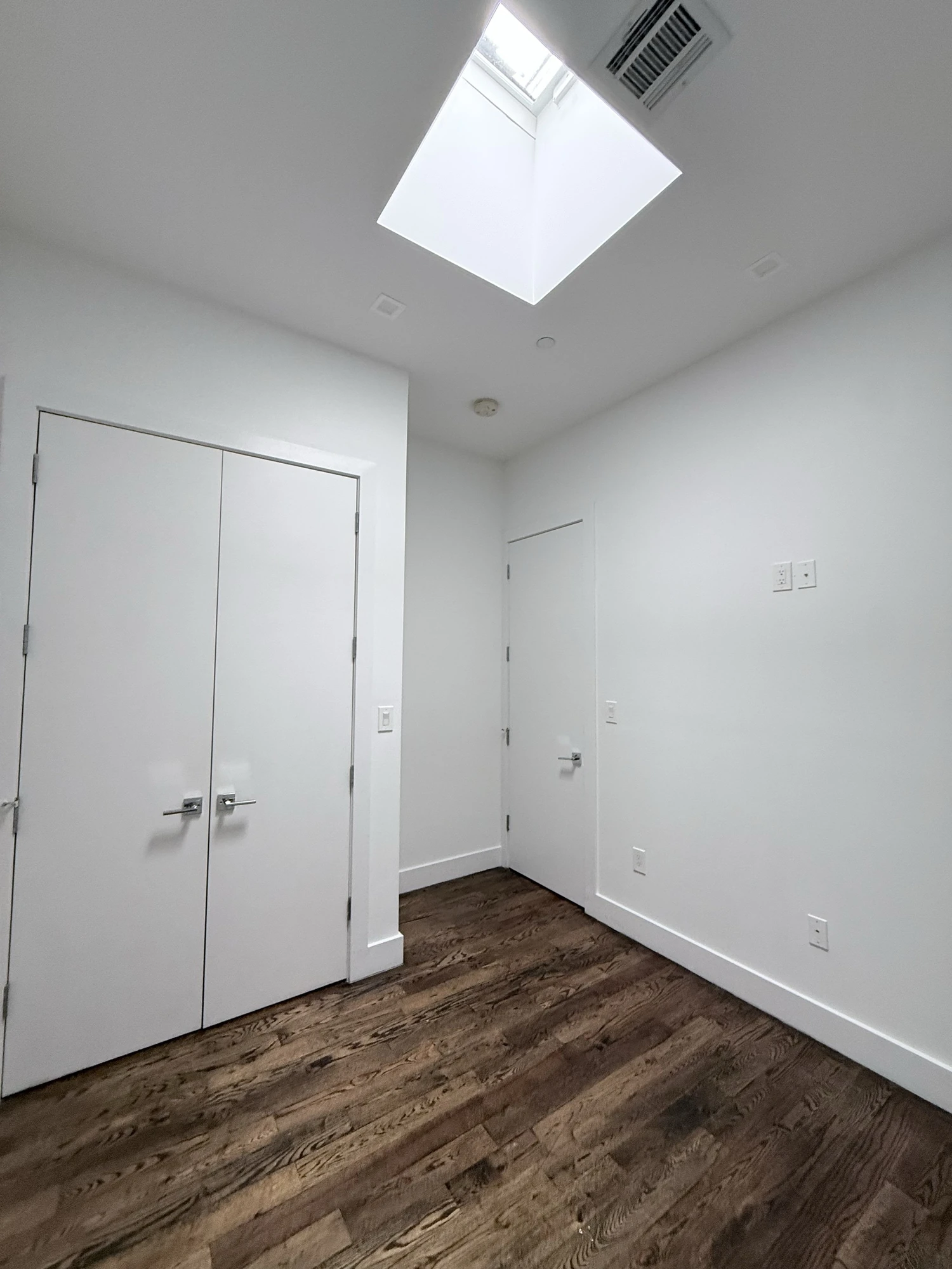 Bright white room with closet doors and skylight before painting, Bedford-Stuyvesant Brooklyn
