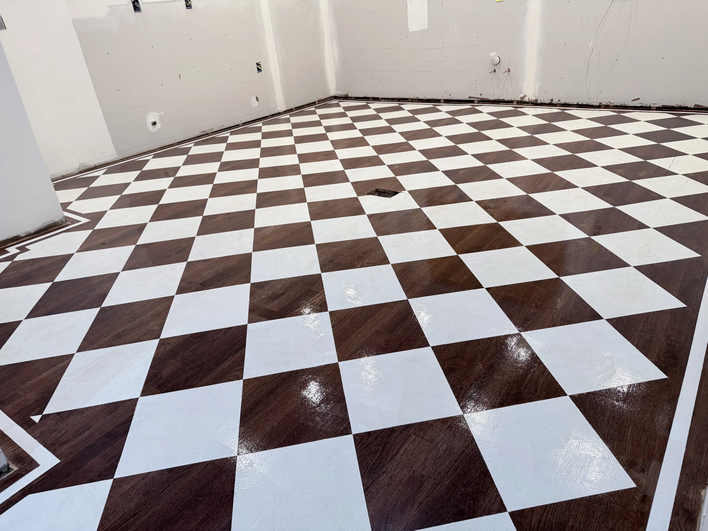 Finished glossy chess-pattern floor from the same corner as the before photo