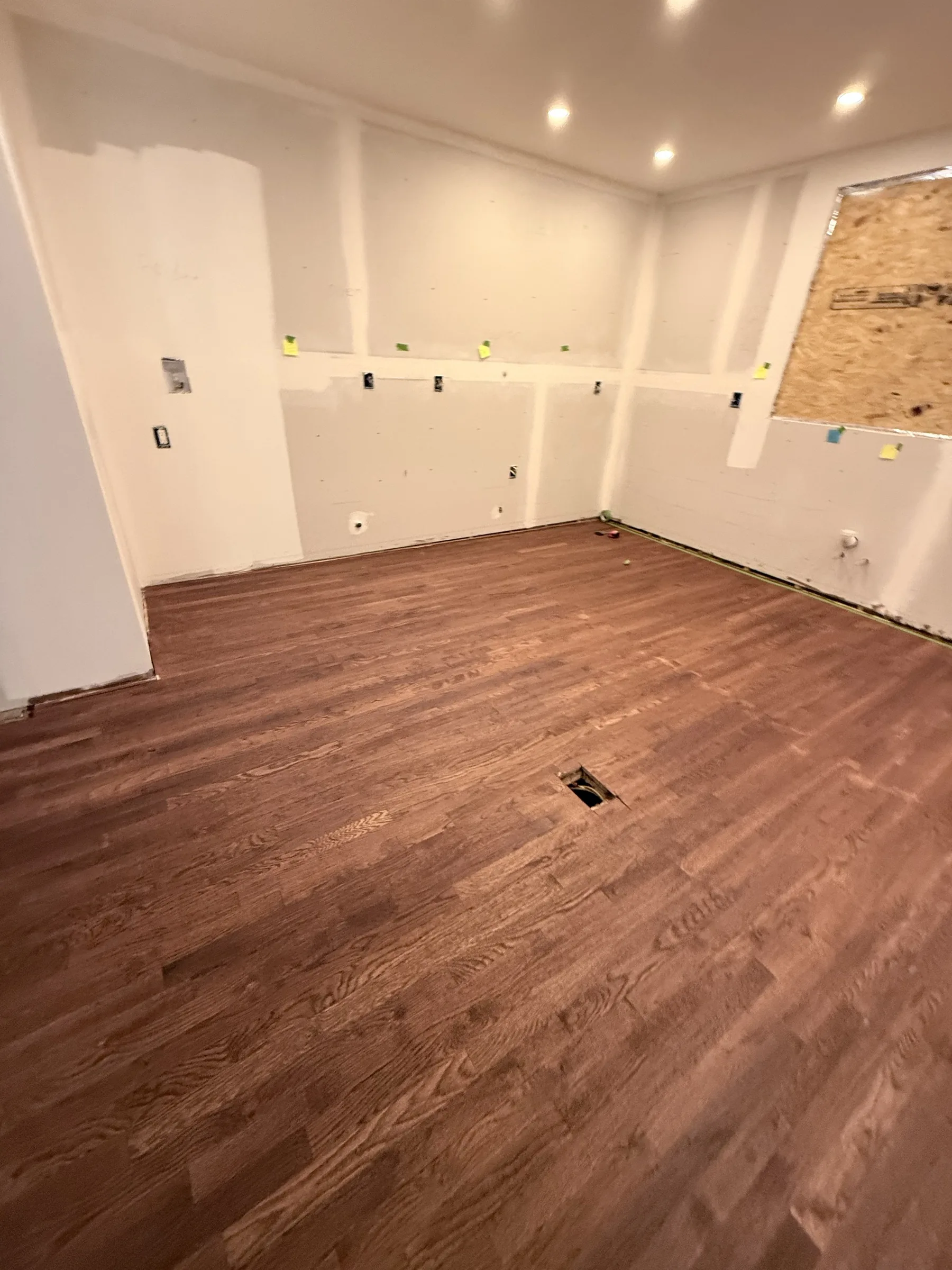 Wide view of the bare stained wood floor before the chess pattern, Baldwin NY