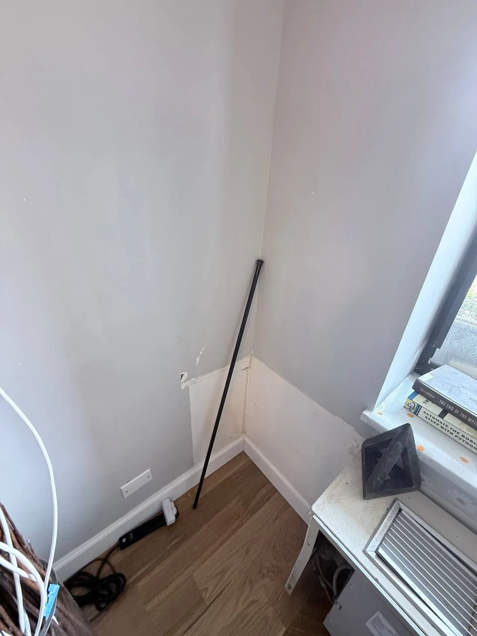 Water-damaged wall section next to the exposed AC unit before repair, NYC apartment