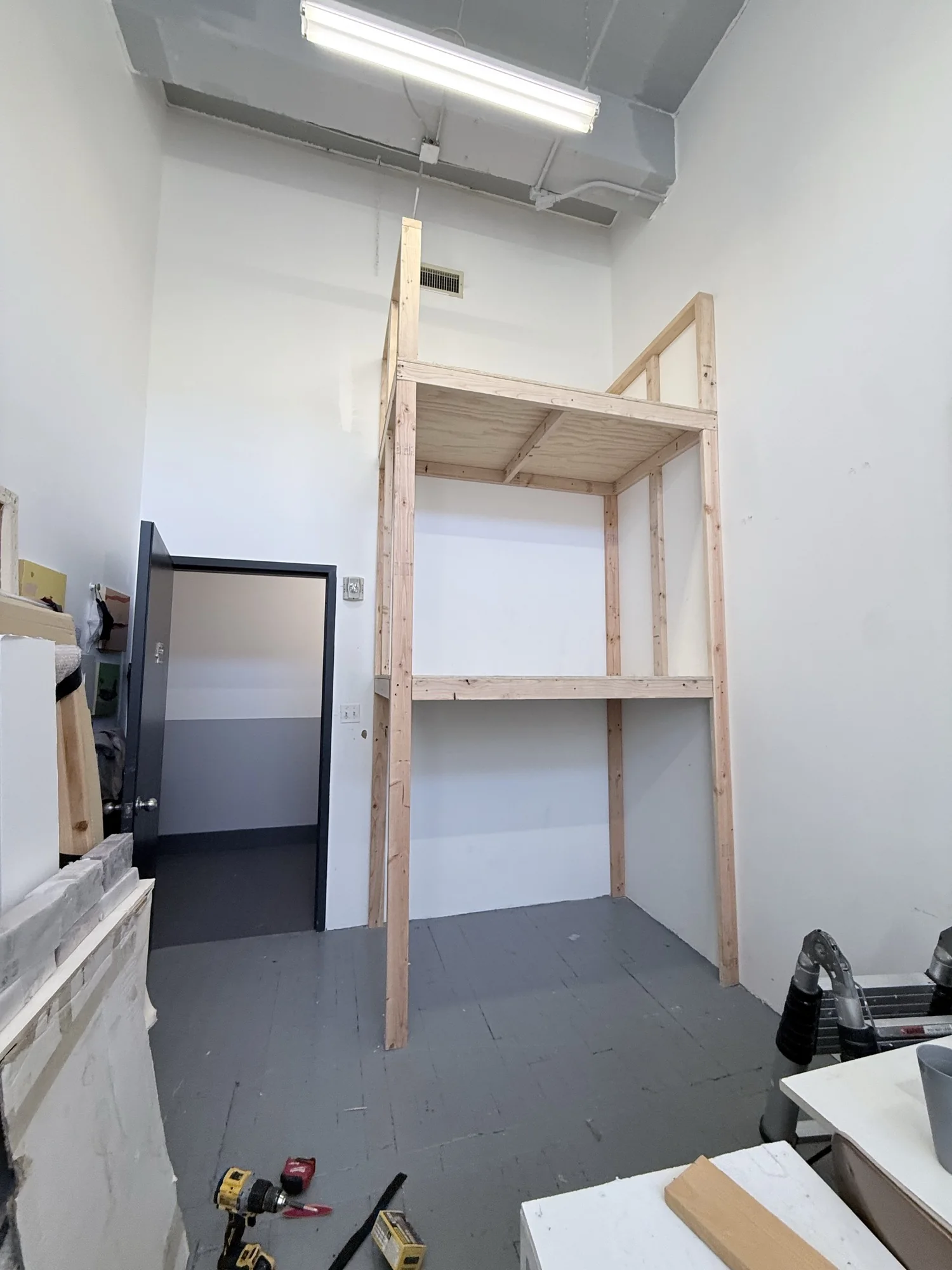 The same studio corner with the finished custom 2x4 and plywood art storage rack