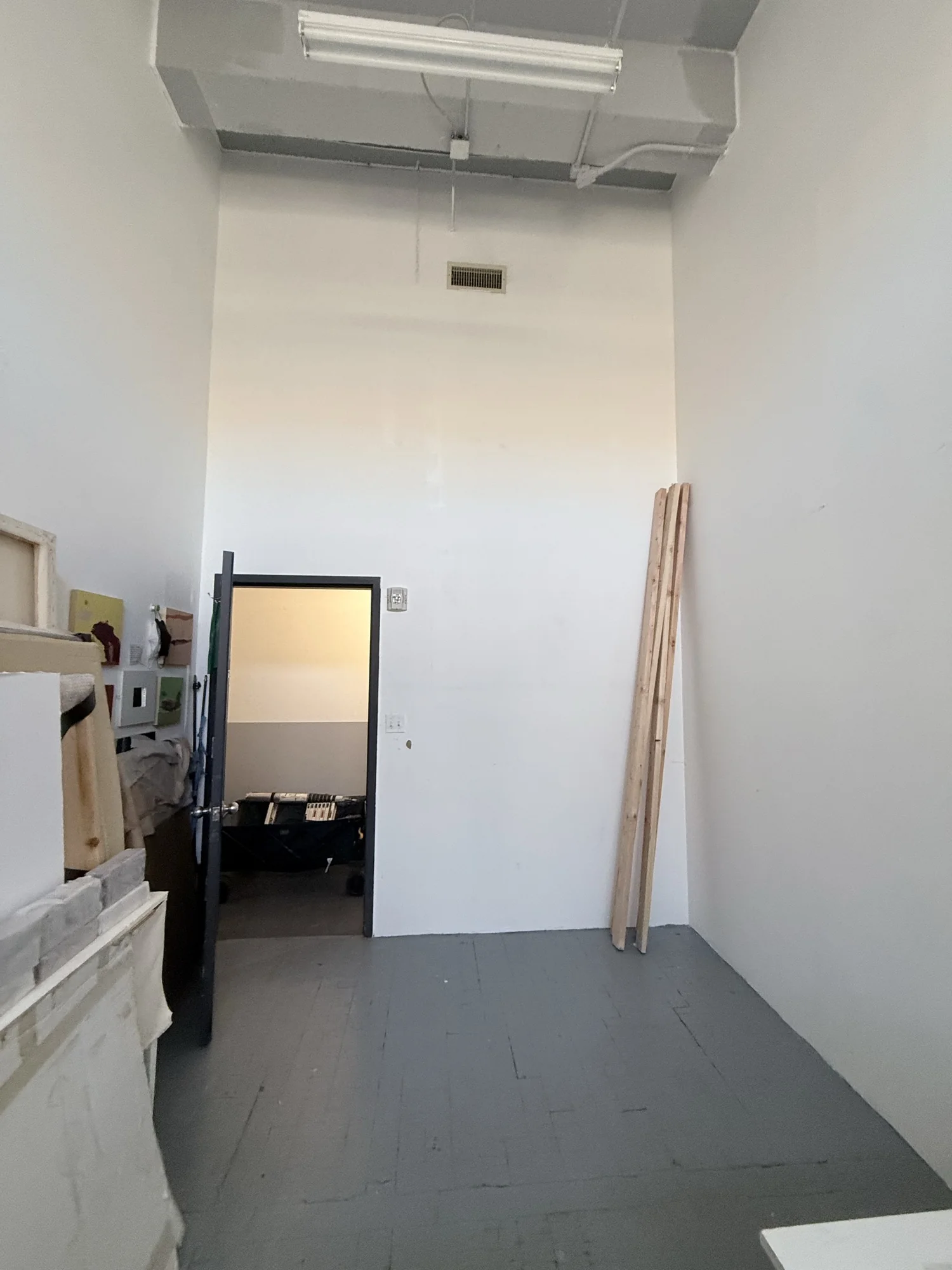 Empty corner of an artist's studio in Astoria, Queens with lumber leaning against the wall before the build