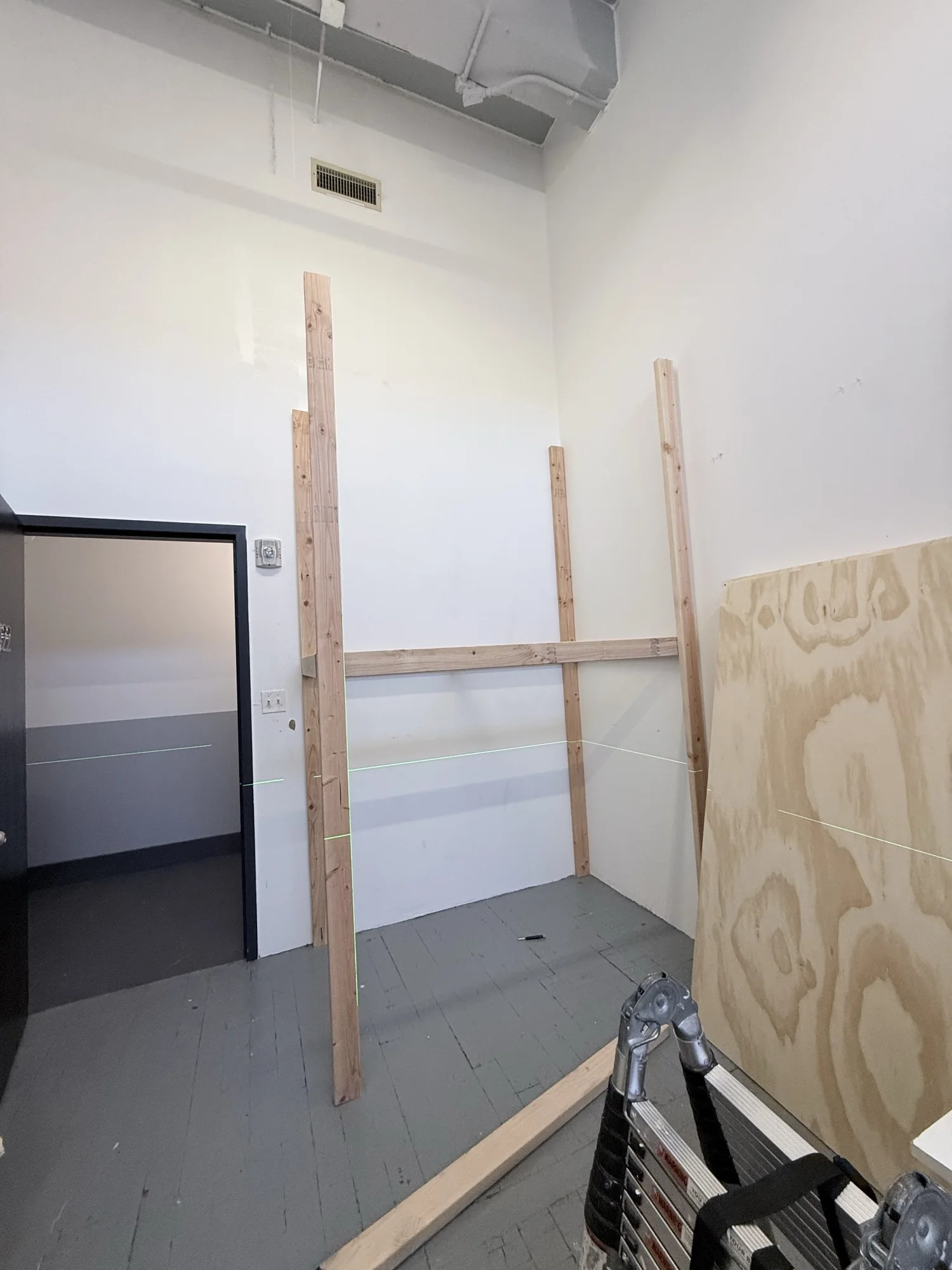 Posts standing with the first rails fixed between them in the studio corner
