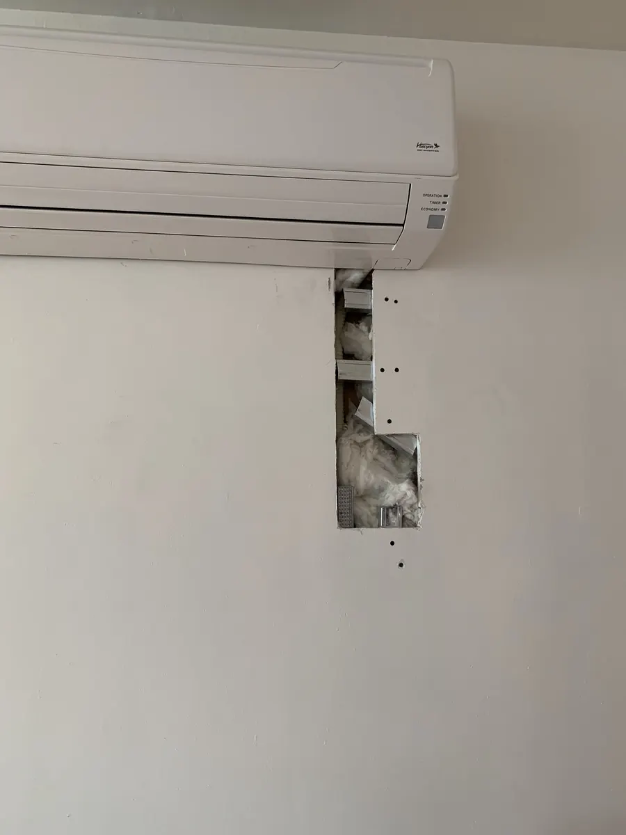 Close view of vertical drywall cutout below indoor mini-split AC unit