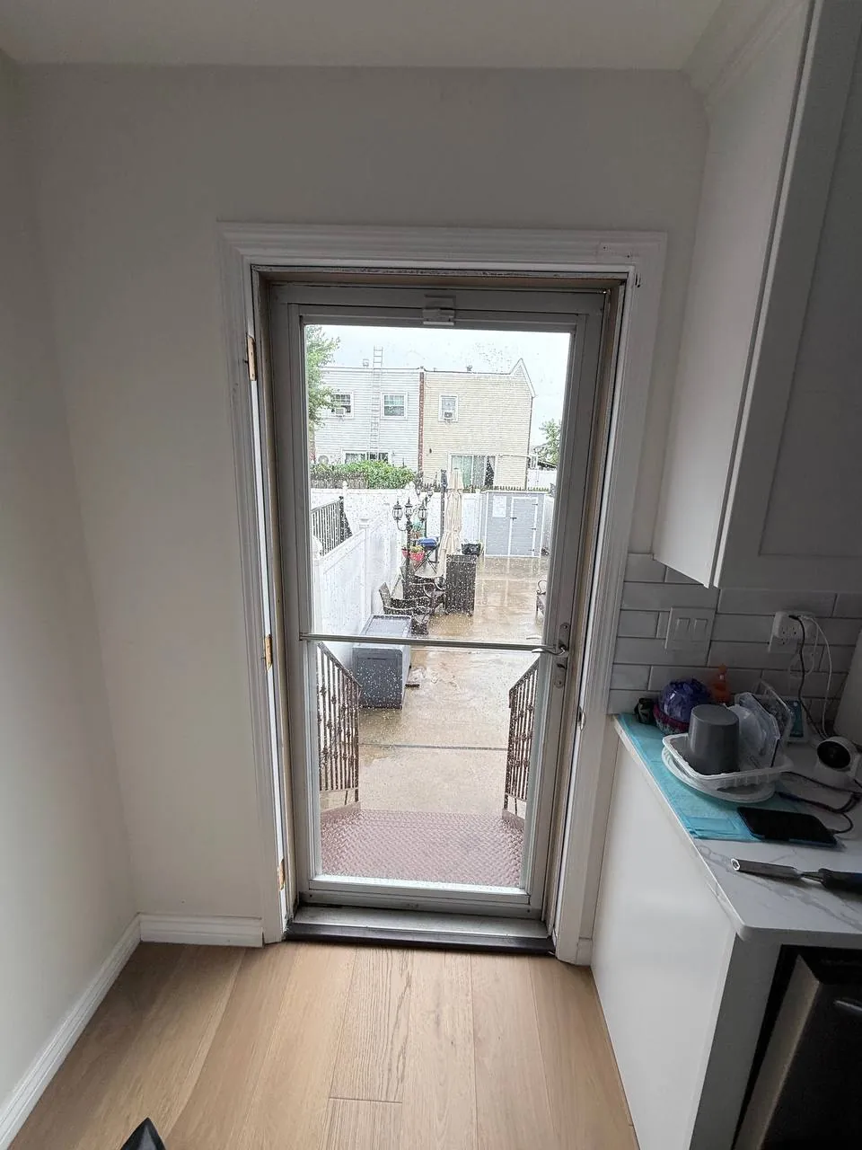 Interior view of the old storm door and glass-insert entry door before replacement
