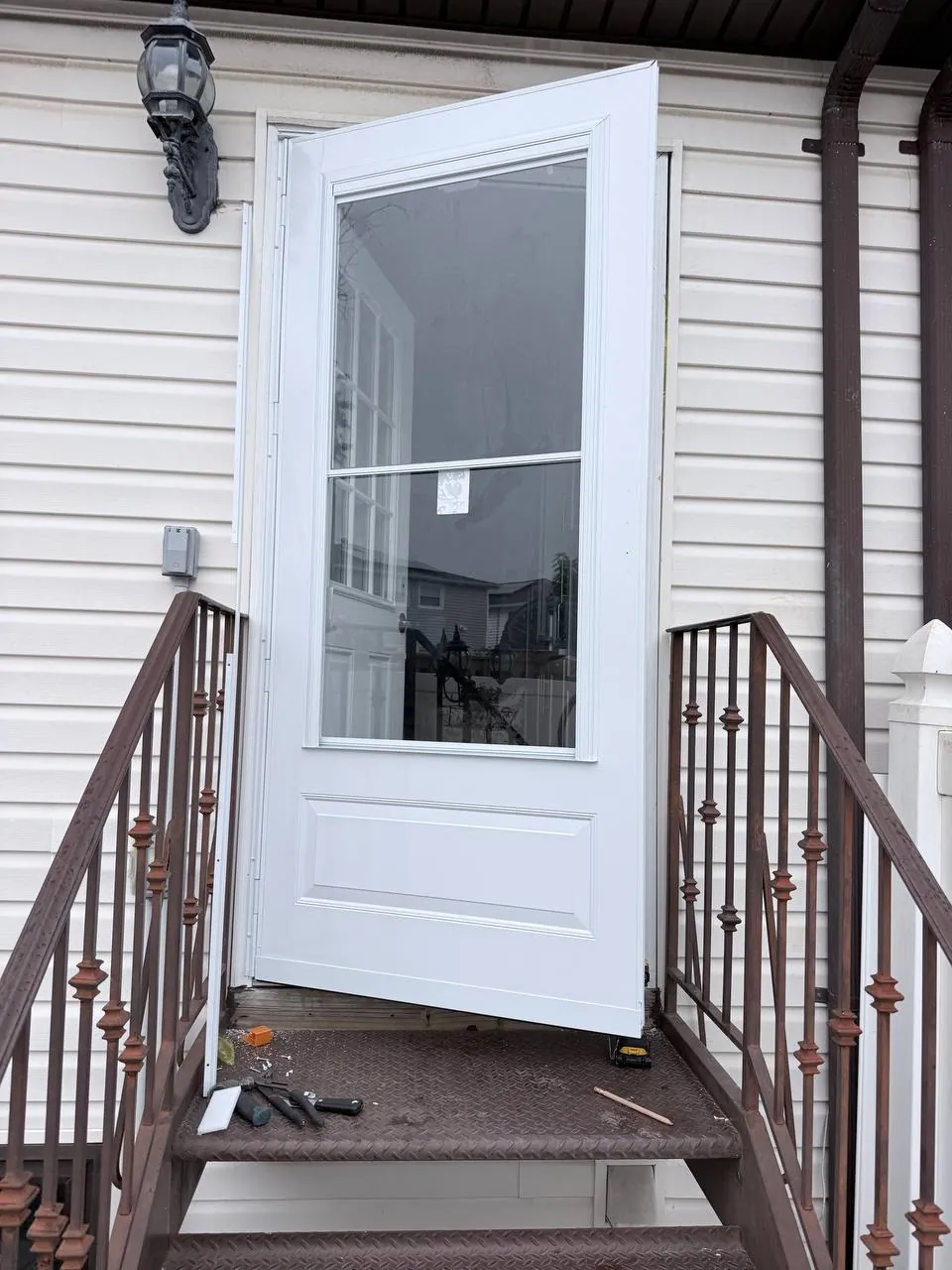 New storm door with glass inserts hung on the same frame, handle on the right