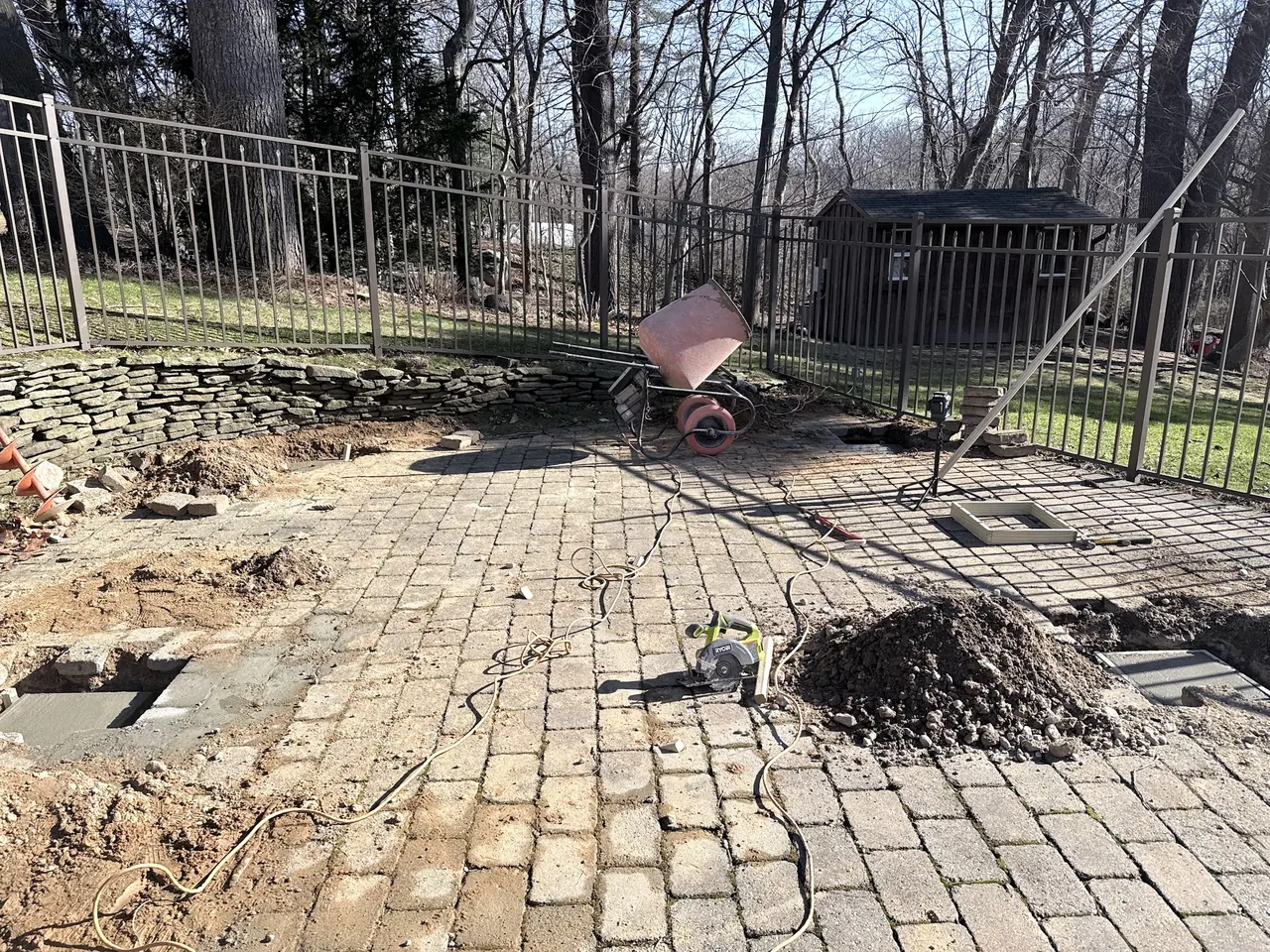 Concrete footing pads with wire reinforcement and forms next to a cement mixer