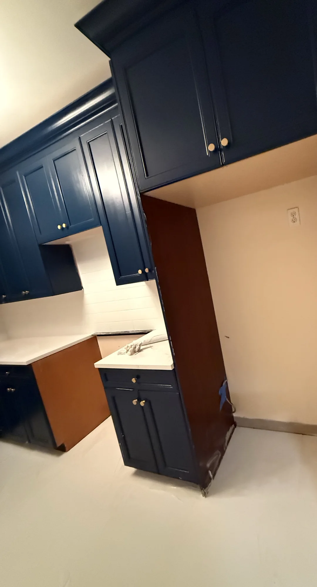 Close view of navy corner cabinets and white subway tile backsplash