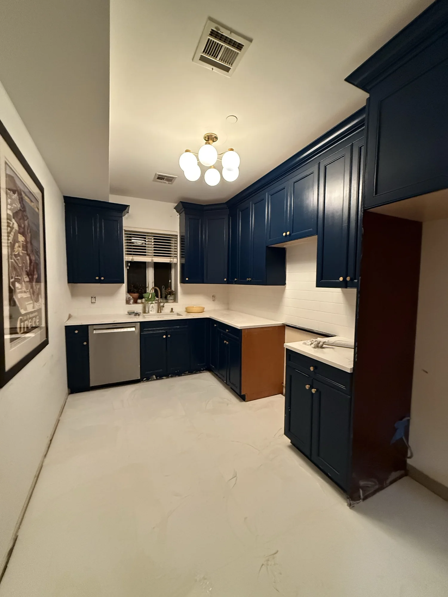 Finished galley kitchen with navy blue cabinets, white subway tile backsplash and a new porcelain tile floor, South Slope Brooklyn