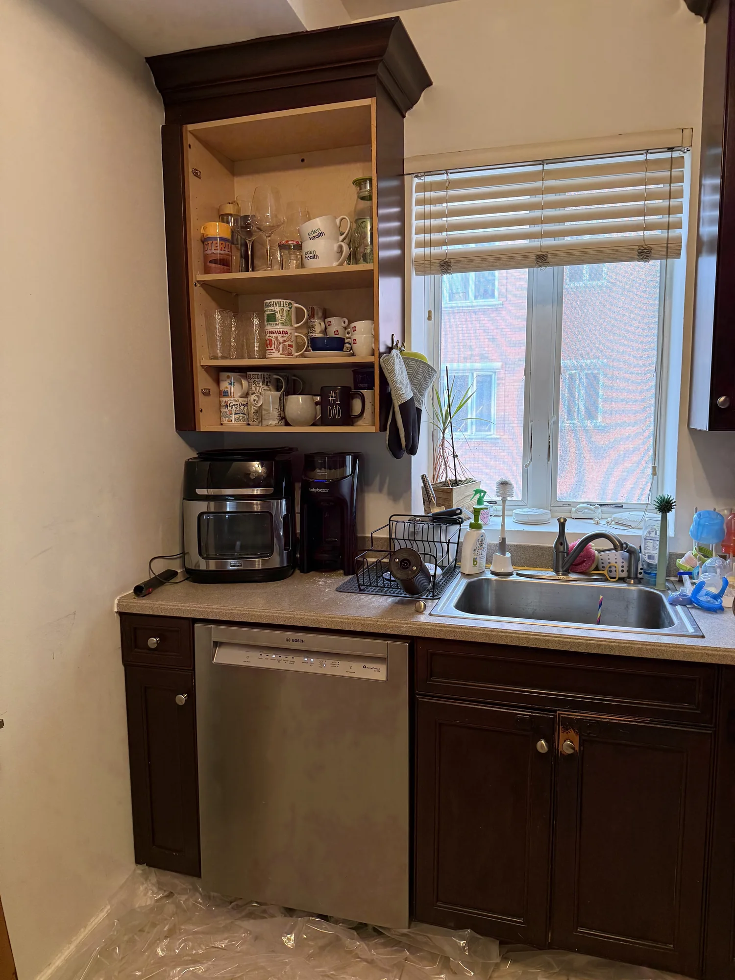 Upper cabinet with its door removed during stripping, showing bare wood inside, Brooklyn kitchen