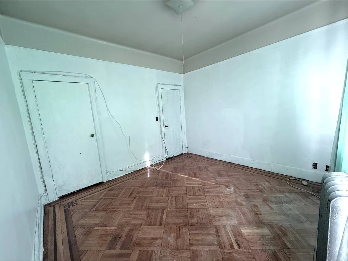 Bedroom before apartment turnover with worn walls and scuffed trim