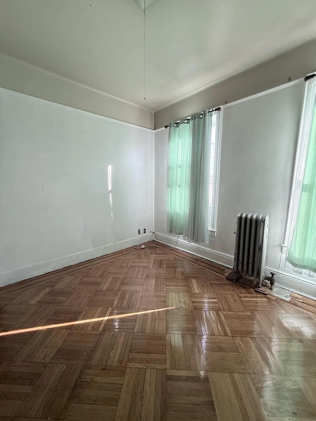 Living room before apartment turnover with dull walls and worn floor