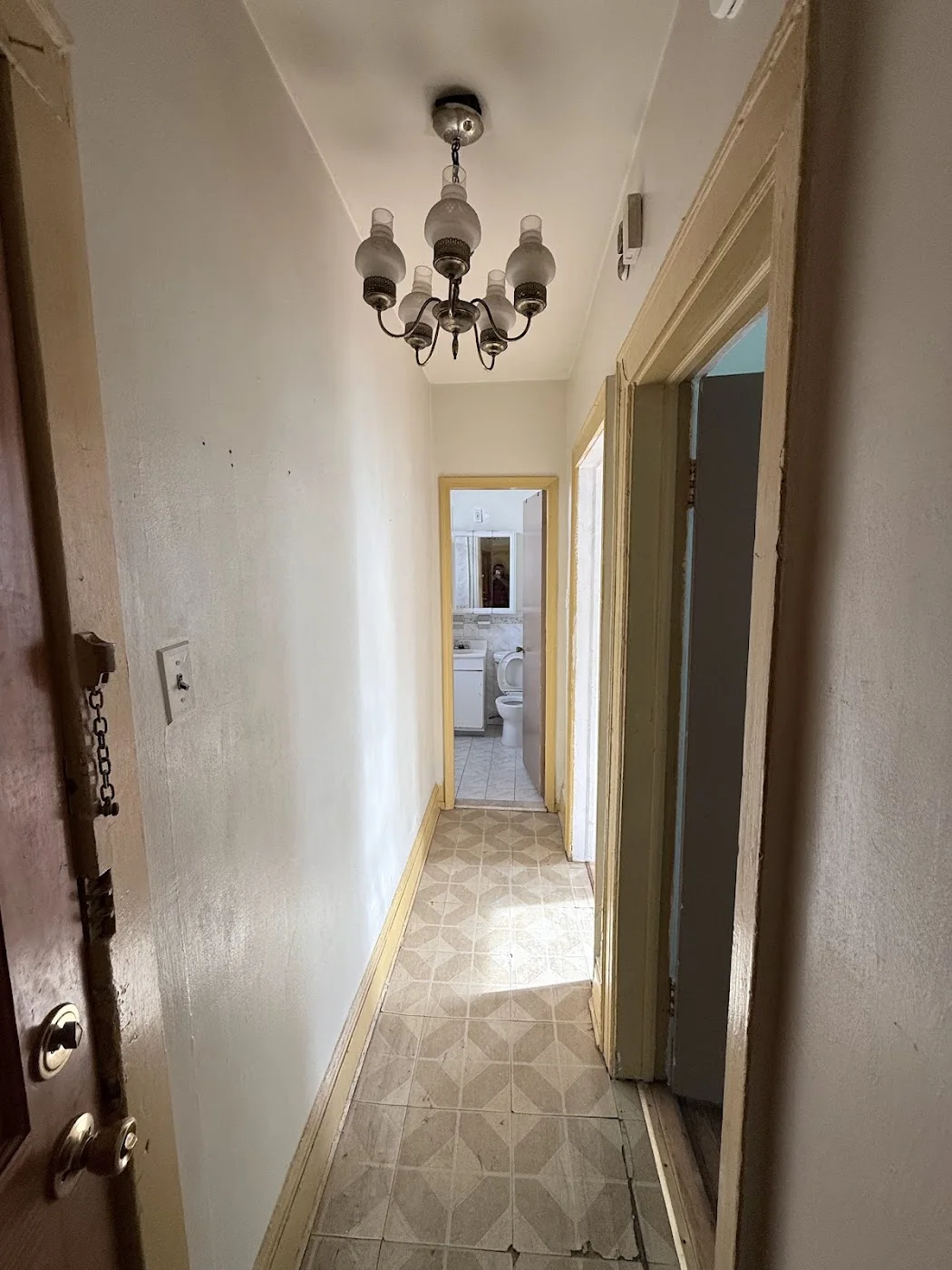 Hallway before apartment turnover with worn old flooring