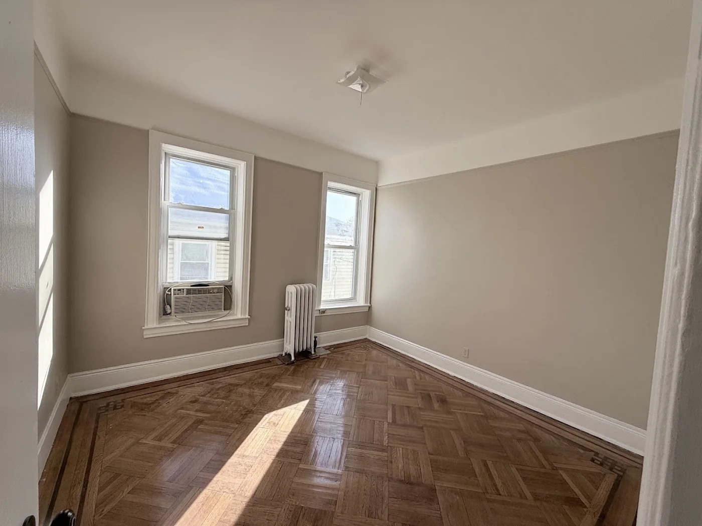 Room after apartment turnover with refinished parquet flooring