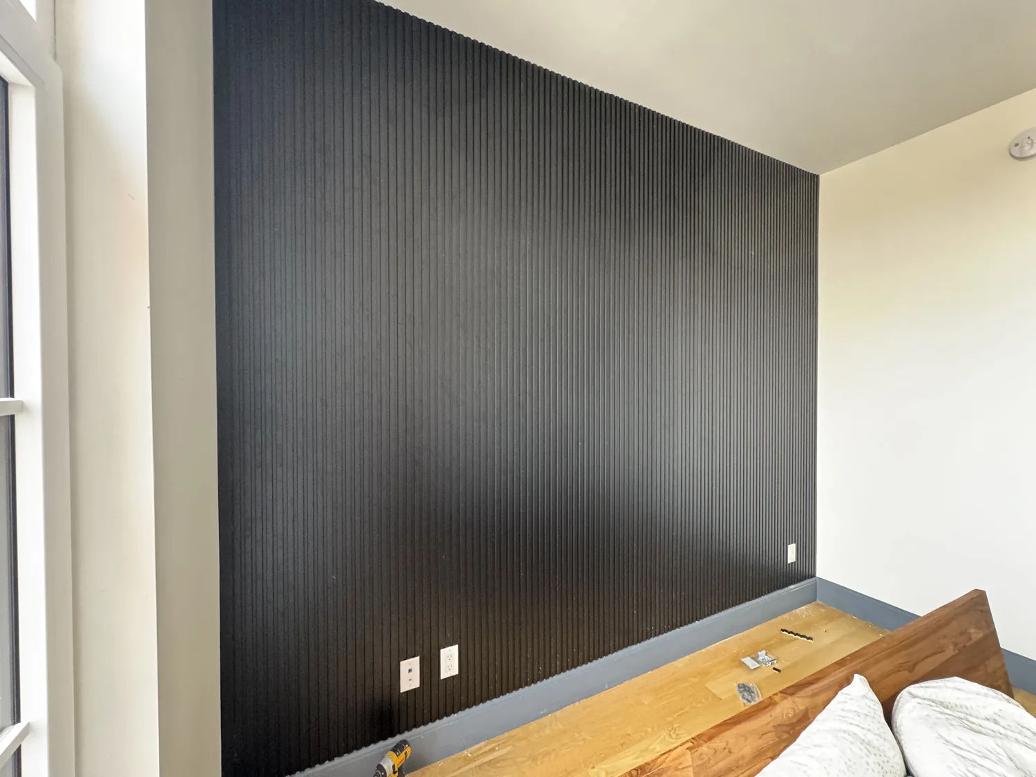 Finished black plastic slat wall panels installed with electrical outlets accessible