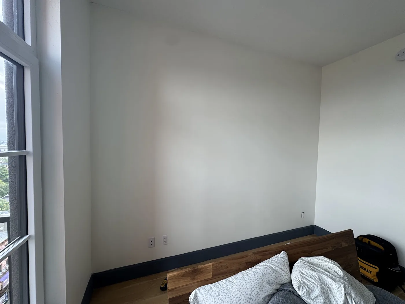 Plain room wall in Brooklyn before black decorative plastic wall panels were installed