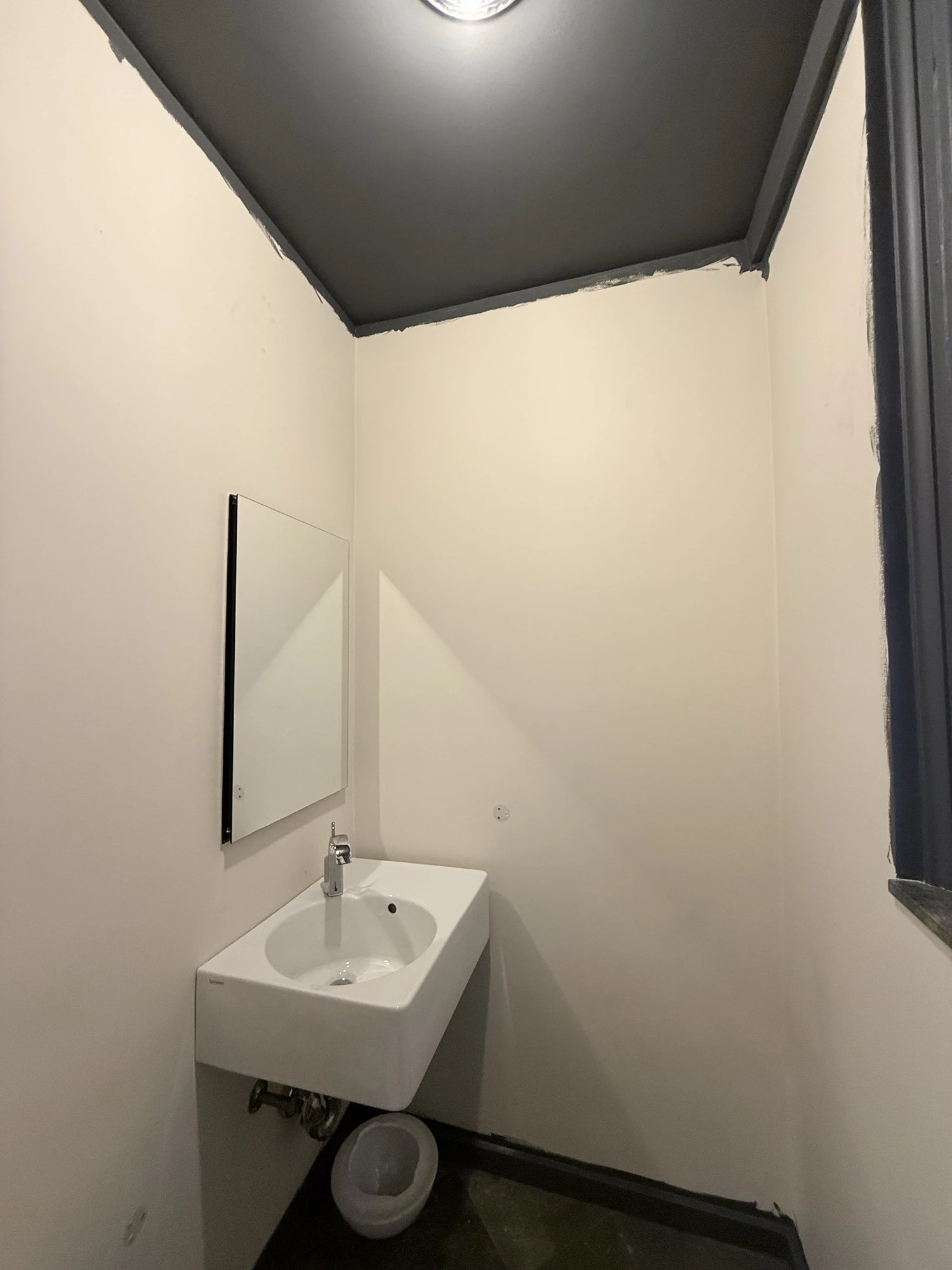 Dark painted ceiling above still-white walls, before the wallpaper went up