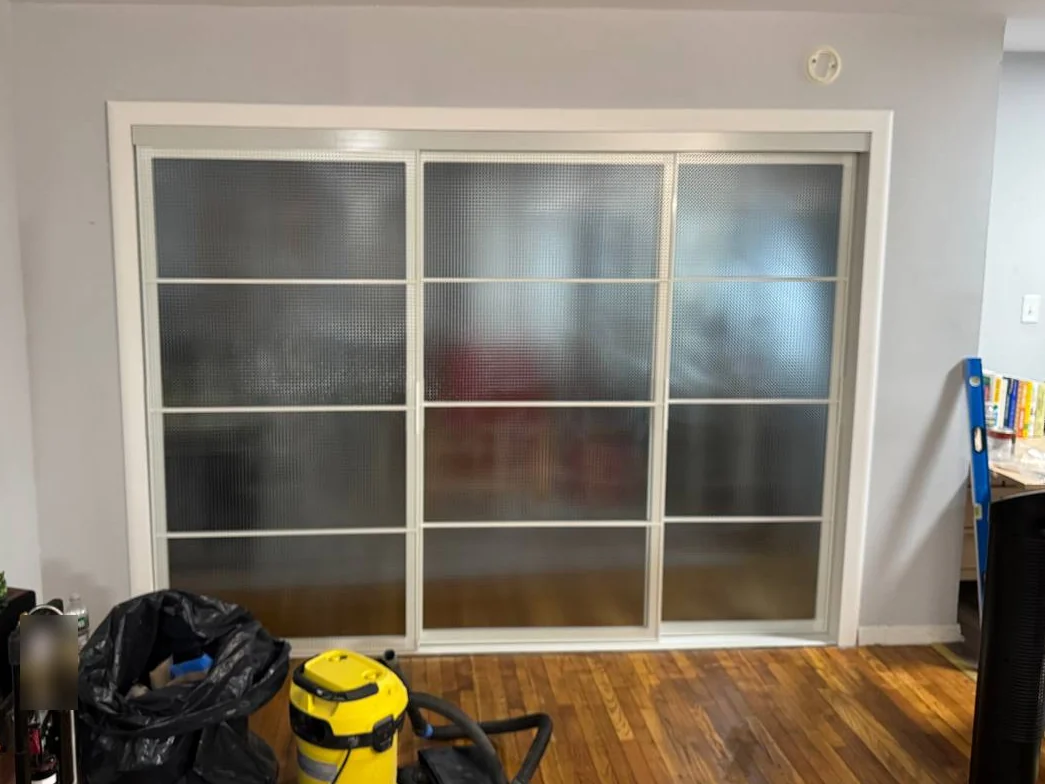 The same wall with a wide cased opening and three sliding textured-glass doors, DUMBO Brooklyn apartment
