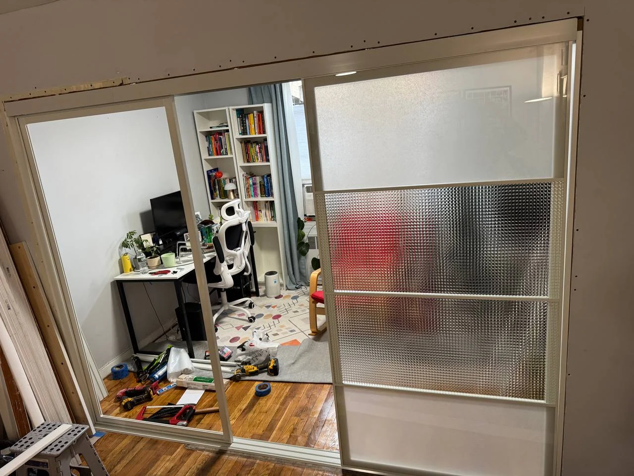 Sliding door frame installed in the widened opening with the first glass panels still in protective film