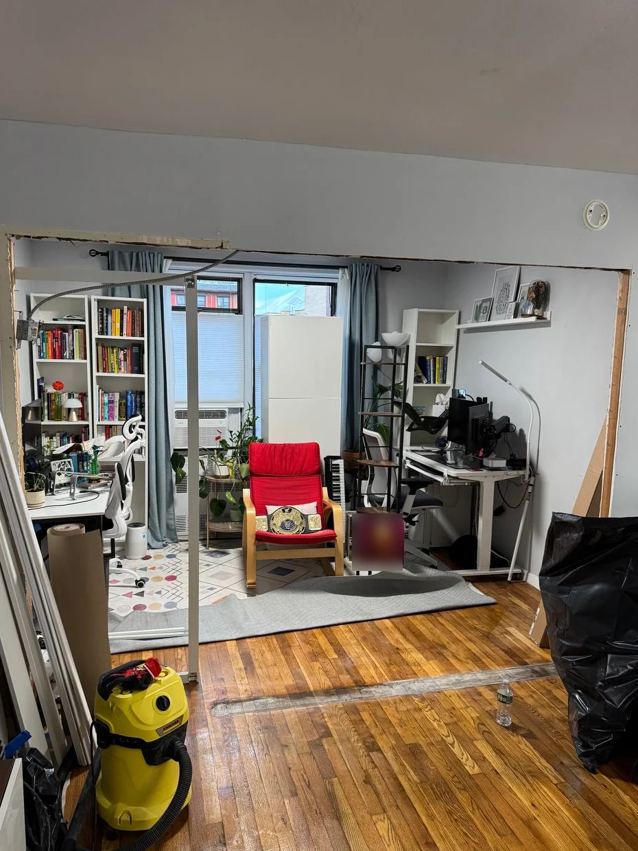 Wall cut back to a wide rough opening between living room and home office during the sliding door project
