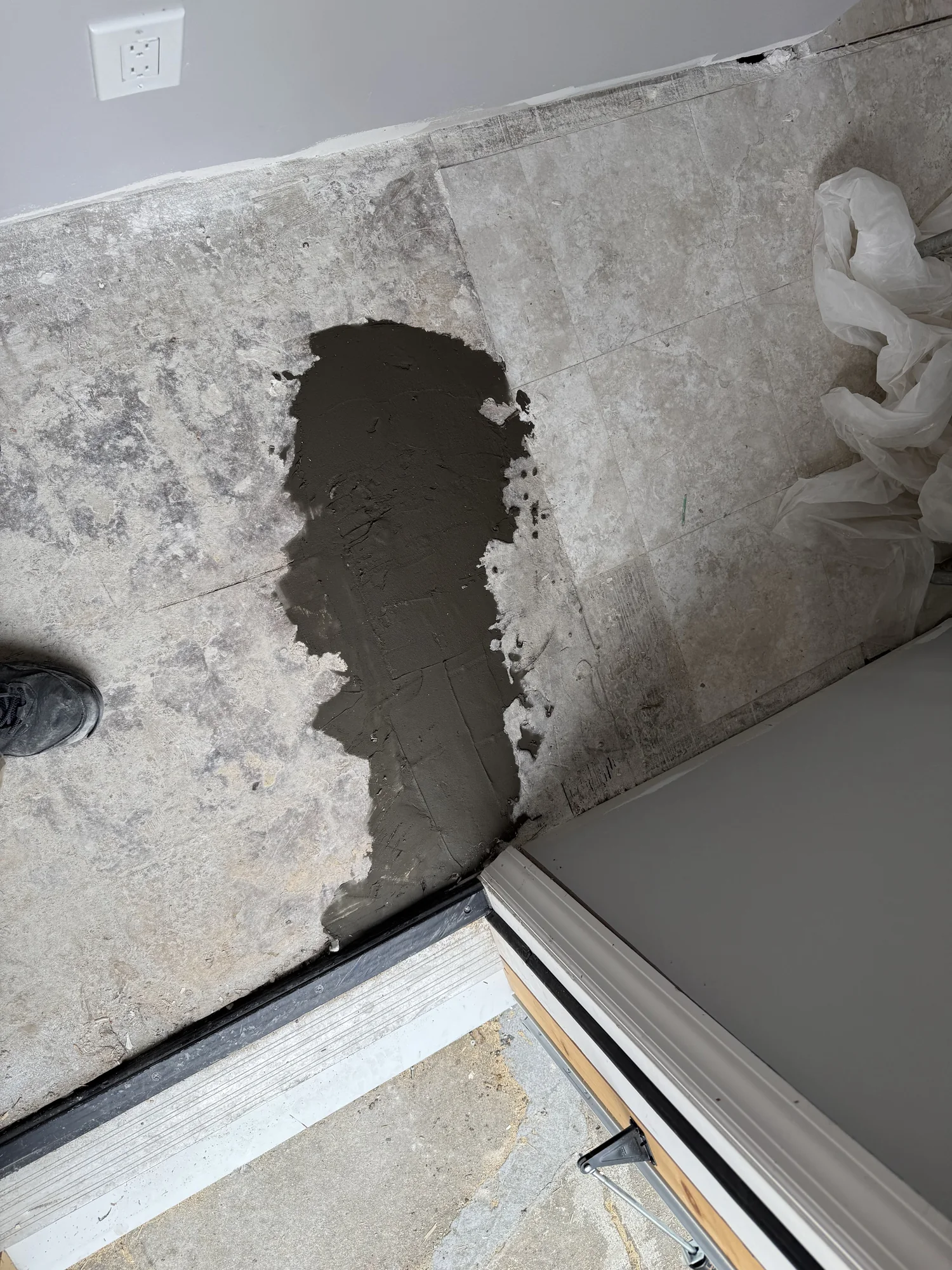 Rough, uneven old floor surface at the doorway between the room and the hallway