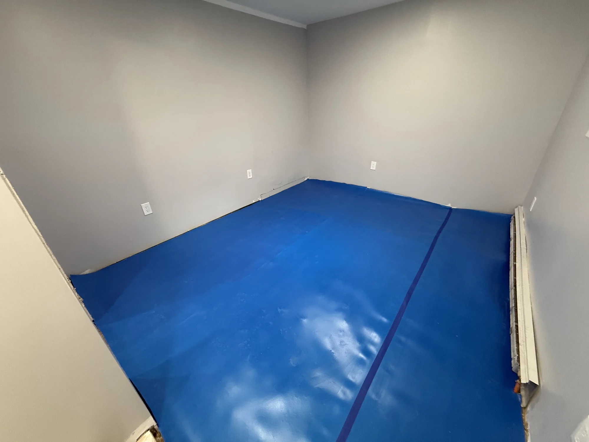 Blue underlayment rolled out over the OSB sheets