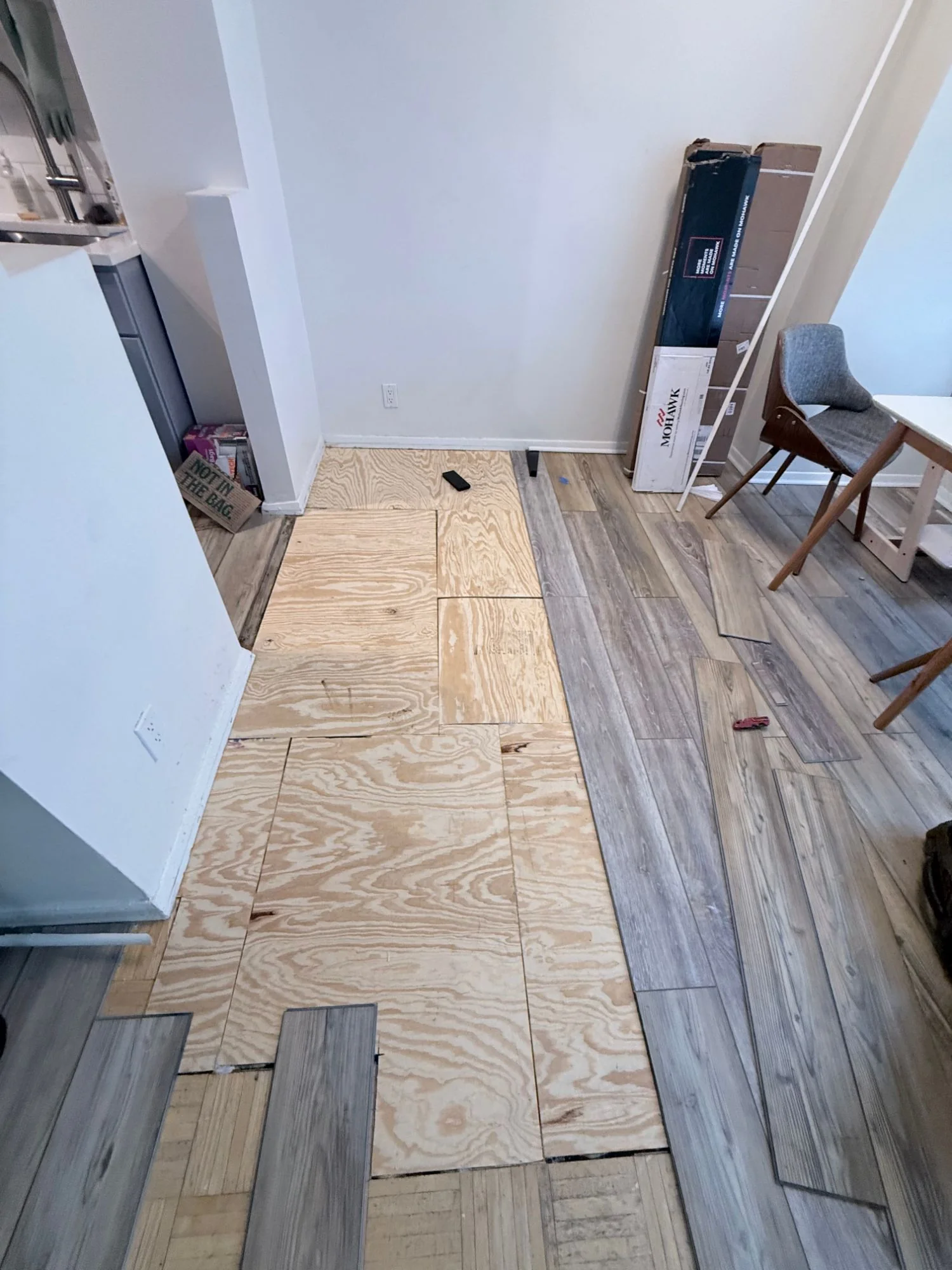 New plywood subfloor glued down where the rotted parquet was removed, Bronx apartment