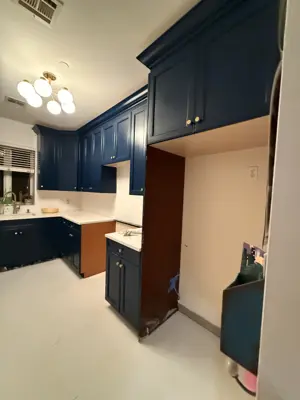 professionally painted navy blue kitchen cabinets with gold hardware in a nyc home