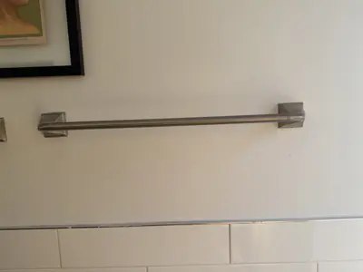 brushed nickel towel bar securely installed on white bathroom wall in nyc home