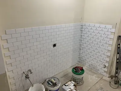 subway tile and mosaic basket-weave tile installation in progress on nyc bathroom walls