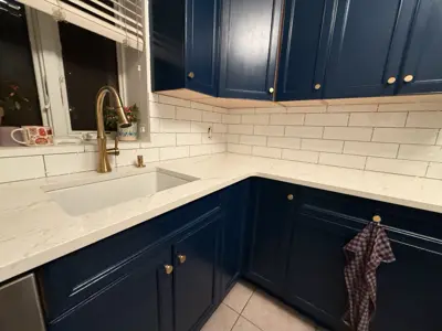 beautifully painted navy blue kitchen cabinets with gold hardware and white subway tile backsplash in nyc
