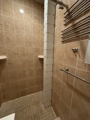 completed bathroom shower tile repair with fresh white grout and caulking in nyc