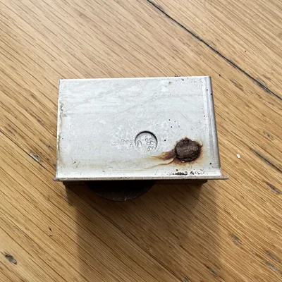 Rusted sash pulley removed from a double-hung window frame